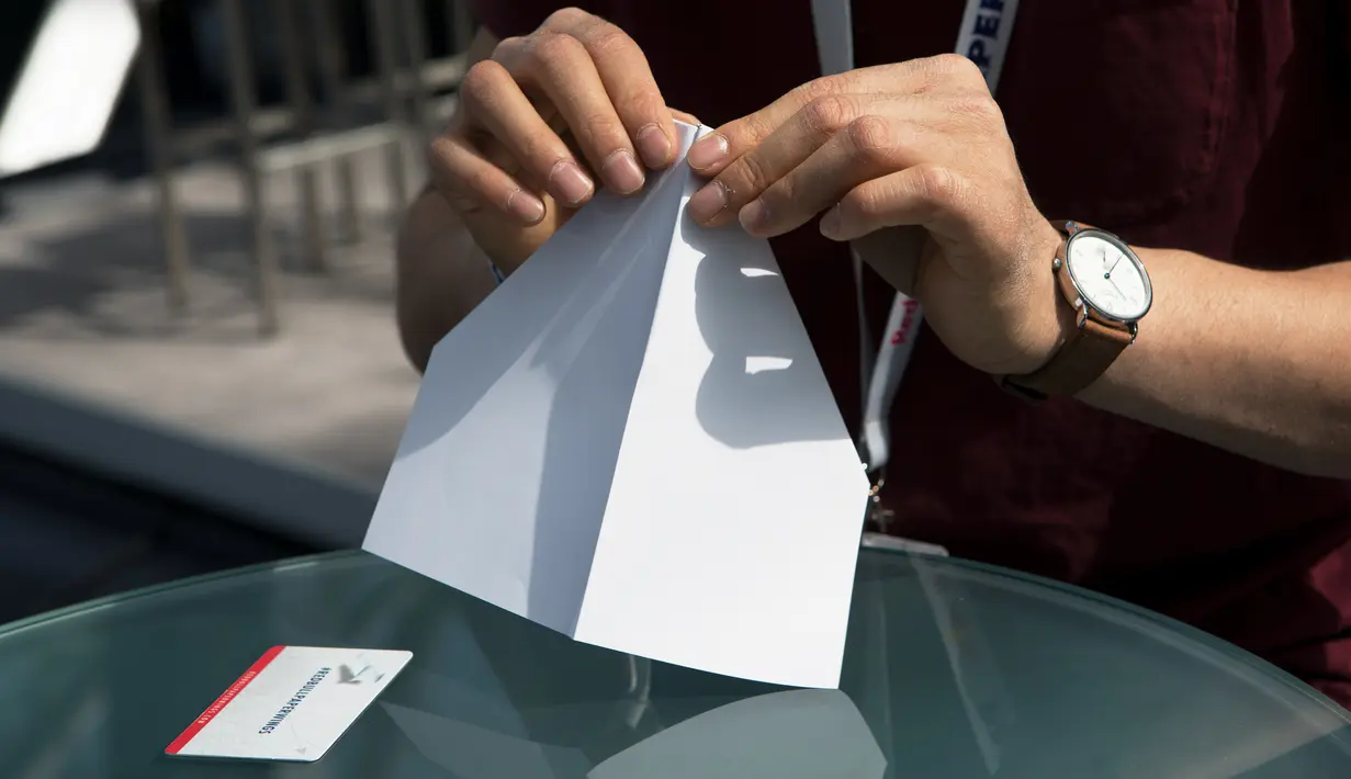Seorang peserta melipat pesawat kertas pada ajang kompetisi Red Bull Paper Wings World Final 2019 di Salzburg, Austria pada 17 Mei 2019. Lebih dari 170 peserta dari seluruh dunia berpartisipasi dalam tiga kategori yaitu jarak terpanjang, waktu terpanjang, dan aerobatik. (ALEX HALADA / AFP)