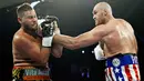 Petinju Inggris Tyson Fury melancarkan pukulan ke arah wajah petinju petinju Jerman Tom Schwarz saat bertarung pada tinju kelas berat di MGM Grand Arena, Las Vegas, AS (16/6/2019). (AP Photo/John Locher)