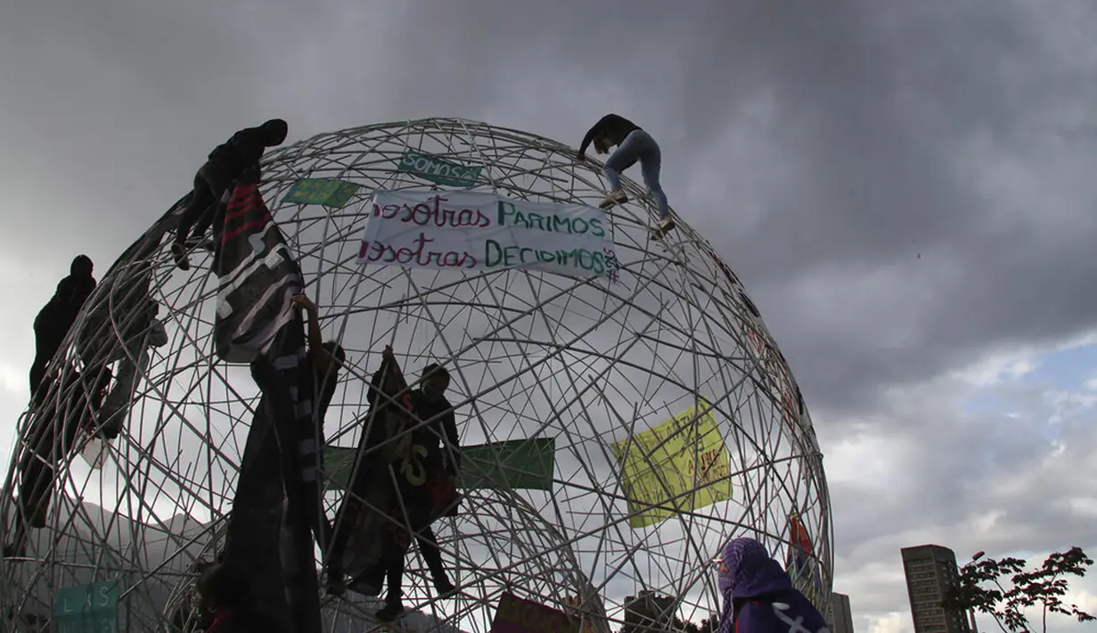 Sejumlah perempuan memasang spanduk pada sebuah bola di Taman Arbolito selama protes hak-hak aborsi di Quito, Ekuador, Senin (28/9/2020). (AP Photo/Dolores Ochoa)