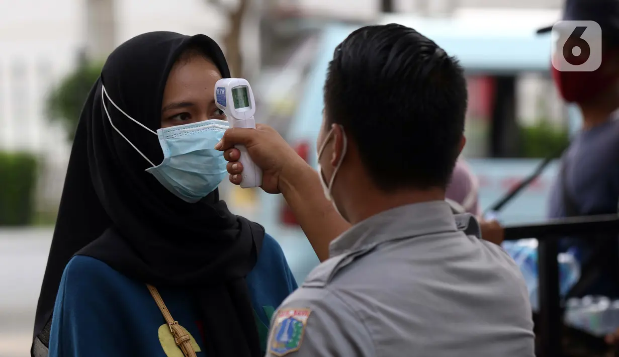 Pengunjung melakukan pengecekan suhu tubuh sebelum memasuki kawasan Kota Tua Jakarta, Kamis (29/10/2020). Libur panjang di masa pemberlakuan PSBB transisi Jakarta dimanfaatkan warga untuk mengunjungi lokasi-lokasi wiisata. (Liputan6.com/Helmi Fithriansyah)
