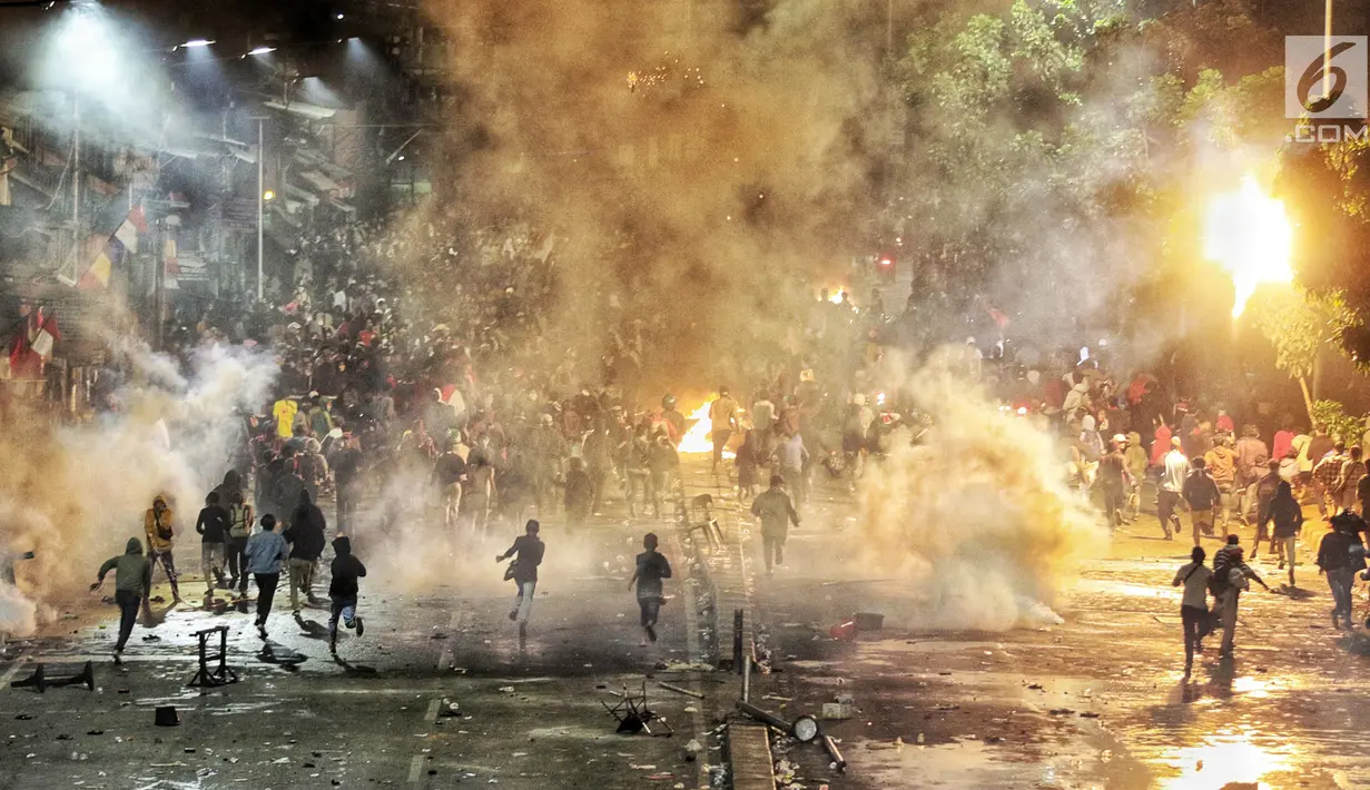 Massa berlari saat Polisi menembakan petasan dan gas air mata ke kerumunan massa di kawasan Pejompongan, Jakarta, Senin (30/9/2019). Demonstrasi menolak UU KPK hasil revisi dan RUU KUHP di depan Gedung DPR/MPR berakhir ricuh. (Liputan6.com/JohanTallo)