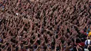 Ribuan pelajar menampilkan Tari Kecak Kolosal saat upaya pemecahan rekor Museum Rekor Dunia Indonesia (MURI) di Pantai Berawa, Badung, Bali, Minggu (25/2). Mereka mengenakan kain kemben bercorak kotak-kotak hitam putih. (AP/Firdia Lisnawati)