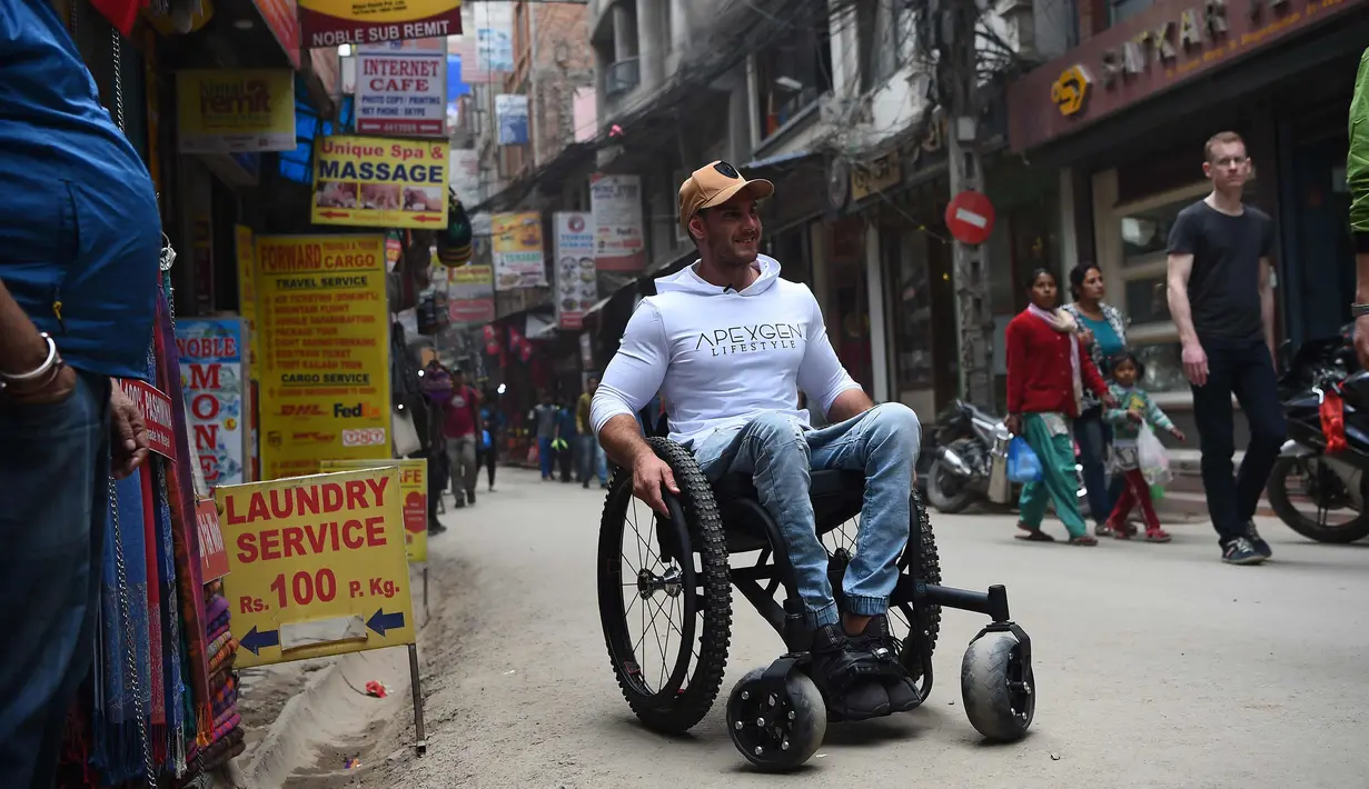 Scott Doolan beraktivitas dengan kursi rodanya di Kathmandu, Nepal, Kamis (15/3). Pria Australia ini bertekad mendaki  hingga basecamp Everest yang berada di ketinggian 5.364 mdpl dengan kursi roda tanpa bantuan. (AFP Photo/Prakash Mathema)