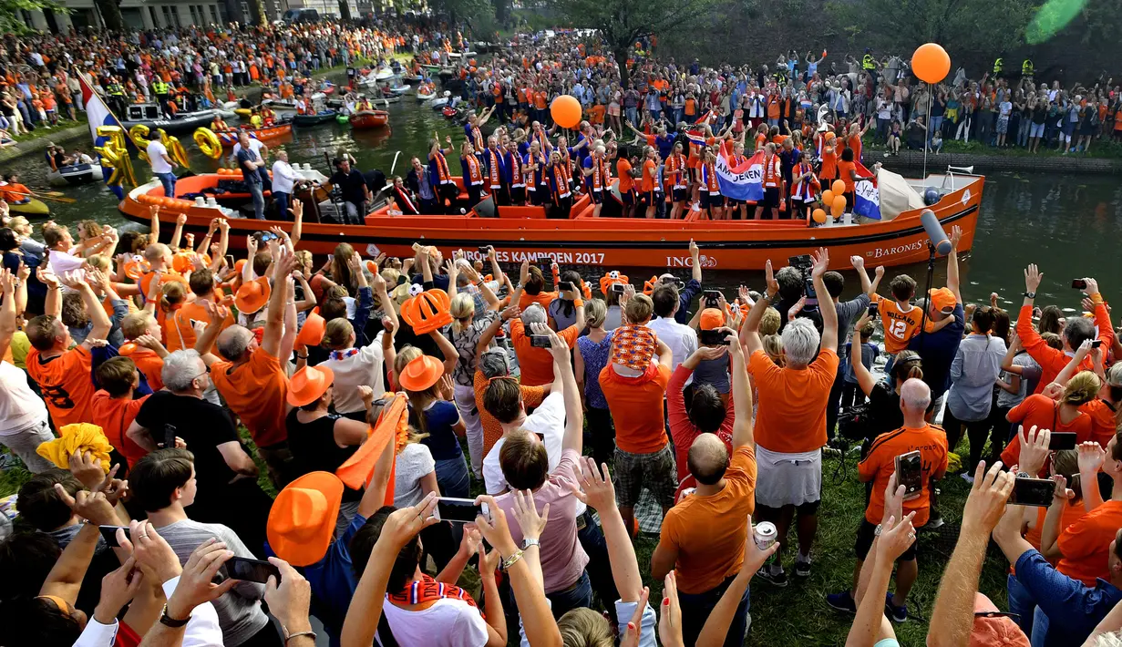 Pendukung bersorak menyambut tim sepak bola wanita Belanda saat merayakan kemenangan di Utrecht, Belanda (7/9). Tim sepak bola wanita Belanda berhasil menjadi juara UEFA Women's Euro 2017 usai mengalahkan Denmark. (AFP Photo/ANP/Olaf Kraak)