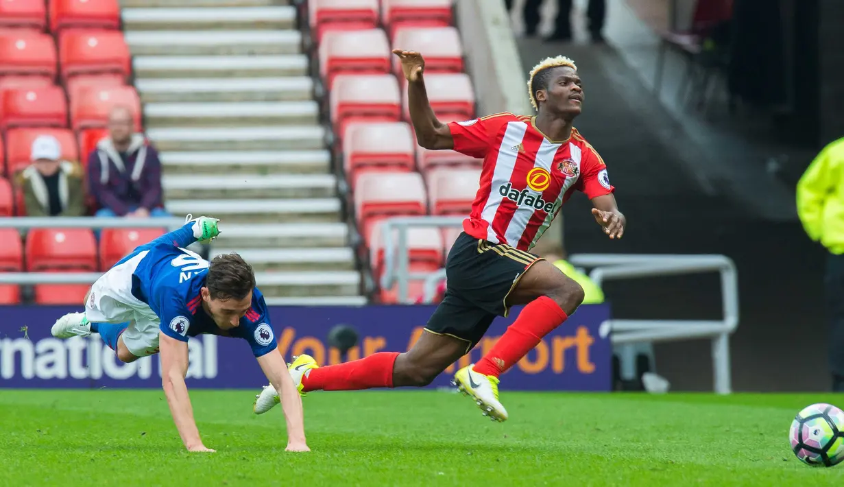 Pemain Manchester United, Matteo Darmian (kiri) terjatuh saat mengejar bola bersama pemain Sunderland, Didier Ndong pada lanjutan Premier League  Stadium of Light, Sunderland, (9/4/2017). Manchester United menang 3-0. (EPA/Peter Powell)