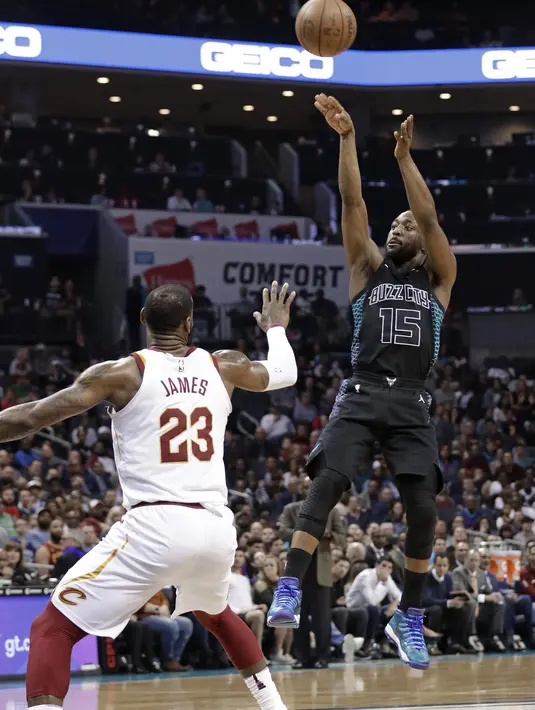 Pebasket Cleveland Cavaliers, LeBron James menghadang pebasket Charlotte Hornets, Kemba Walker, pada laga NBA di Spectrum Center, Rabu (28/3/2018). Cleveland Cavaliers menang 118-105 atas Charlotte Hornets. (AP/Chuck Burton)