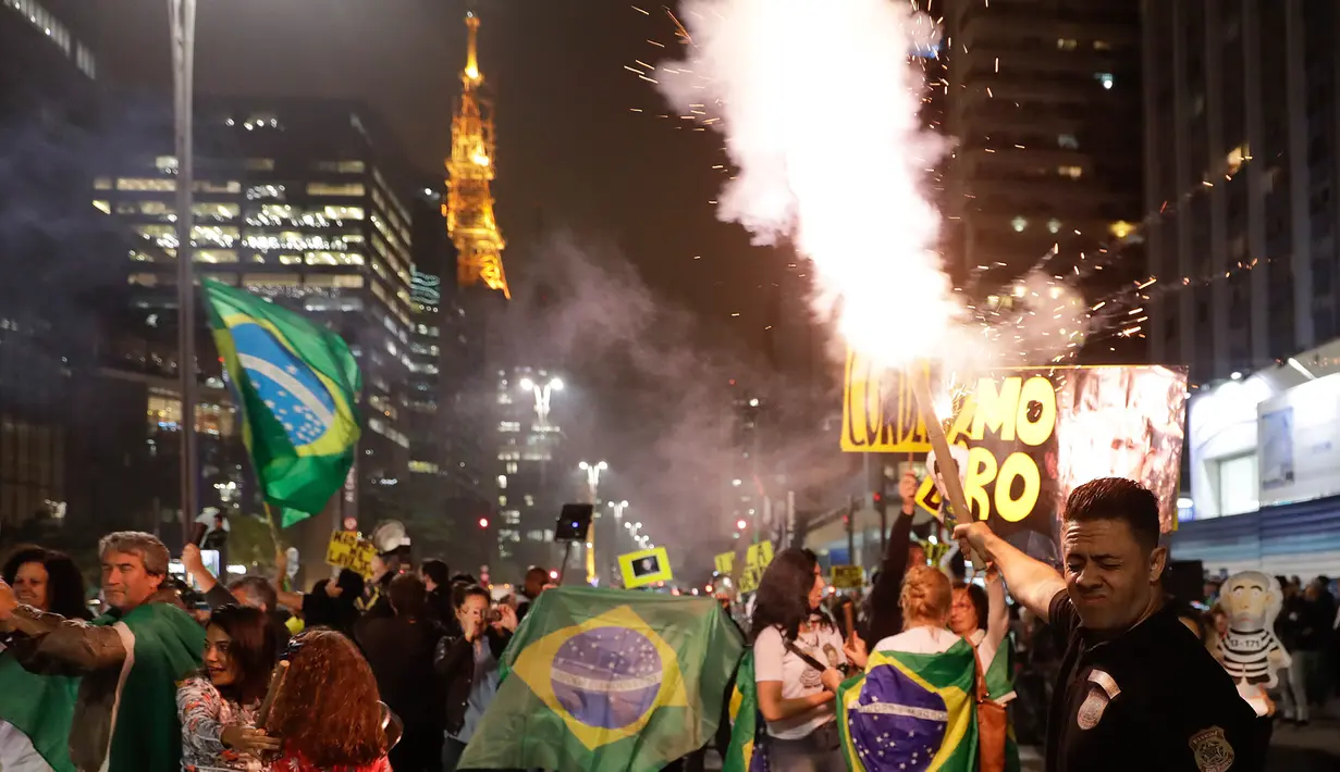 Demonstran merayakan keputusan Hakim Sergio Moro menjatuhkan hukuman ke mantan Presiden Brasil Luiz Inacio Lula da Silva, di Sao Paulo, Brasil, (12/7). Silva divonis bersalah atas tuduhan korupsi. (AP Photo/Andre Penner)