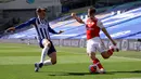 Pemain Brighton & Hove Albion, Solly March berusaha memblok tendangan bek Arsenal, Kieran Tierney pada lanjutan pertandingan Liga Inggris di The American Express Community Stadium, Sabtu (20/6/2020). Sempat unggul, Arsenal justru tumbang 1-2 di tangan Brighton. (Richard Heathcote/Pool via AP)
