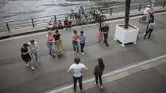 Orang-orang menari di tepi Sungai Seine, Paris, Prancis, Minggu (11/7/2021). Prancis telah mengakhiri kewajiban mengenakan masker di luar ruangan dan pencabutan jam malam sejak pertengahan Juni lalu menyusul penurunan kasus COVID-19. (AP Photo/Lewis Joly)