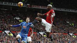 Aksi pemain Manchester United, Paul Pogba mencoba merebut bola dari pemain AFC Bournemouth, Adam Smith (kiri) pada lanjutan Premier League pekan ke-27 di Old Trafford, Manchester, (4/3/2017). MU diatahan imbang 1-1. (Martin Rickett/PA via AP)