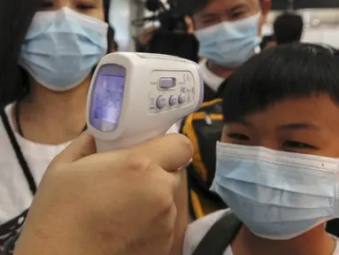 Seorang anak laki-laki menjalani pemeriksaan suhu badan saat tiba di Bandara Internasional Bangkok Suvarnabhumi, Thailand, Minggu (21/6/2015). WHO mencatat ada 1.334 kasus MERS di 26 negara. (REUTERS/Kerek Wongsa)