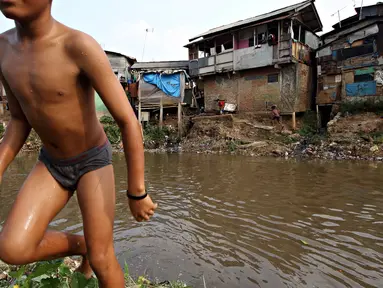 Seorang anak bermain di bantaran Sungai Ciliwung, Jakarta, Selasa (13/10/2015). Berdasarkan data BPS DKI Jakarta, angka kemiskinan di Jakarta tahun 2015 mengalami penurunan 0,16 persen dibandingkan tahun lalu. (Liputan6.com/Immanuel Antonius)
