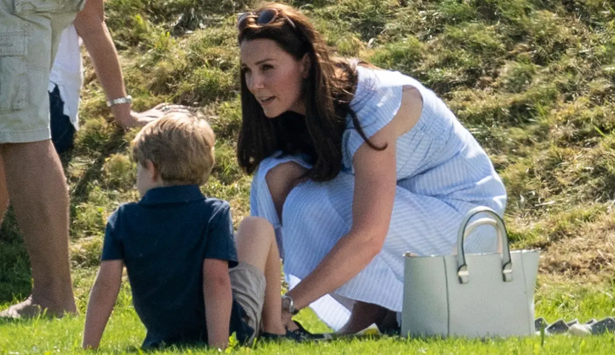 Kate Middleton merapikan sepatu Pangeran George saat menghadiri acara amal Kerajaan Inggris bertajuk Maserati Royal Charity Polo Trophy di Beaufort Polo Club, Gloucestershire, Minggu (10/6). Pangeran William ambil bagian dalam kegiatan tersebut (AP Photo)