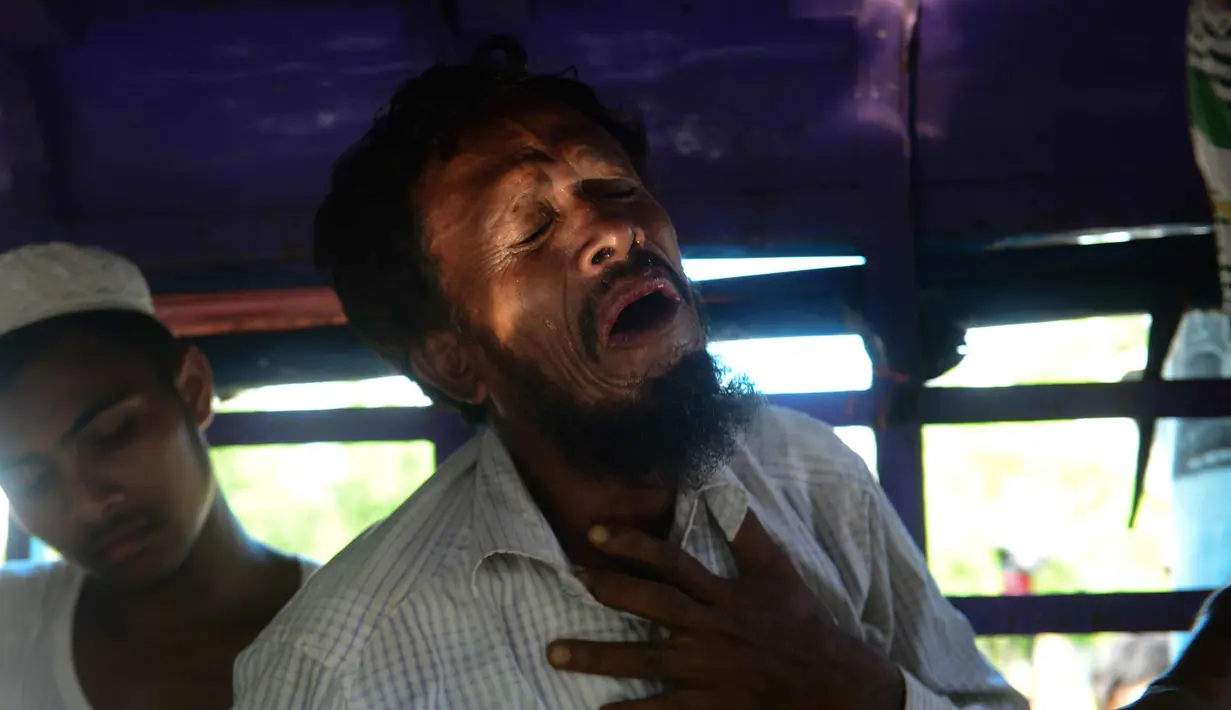 Alif Jukhar menangis setelah menguburkan kedua orang tuanya di pemakaman di Sha Porir Dwip, Teknaf (9/10). Alif Jukhar, yang telah lama tinggal di Bangladesh, kehilangan sembilan saudara termasuk ibu dan ayahnya. (AFP Photo/Munir Uz Zaman)