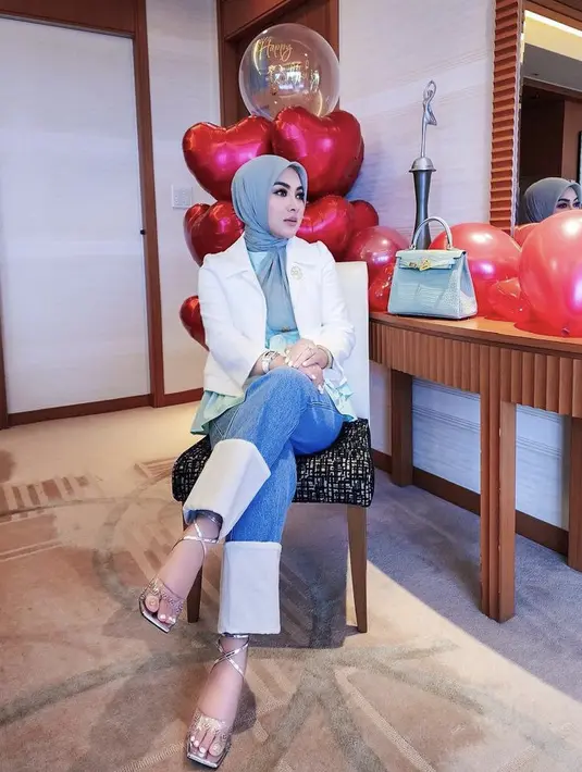 Syahrini juga mengenakan heels dengan strap transparan dan strap silver. Terlihat di sampingnya terdapat tas Hermes warna biru. [Instagram/(@princessyahrini]