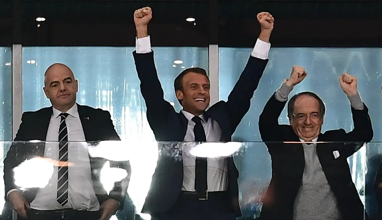 Presiden Prancis, Emmanuel Macron berselebrasi setelah timnas negaranya menang atas Belgia pada laga semifinal Piala Dunia 2018 di St Petersburg Stadium, Selasa (10/7). Prancis lolos ke final setelah mengalahkan Belgia 1-0. (Giuseppe CACACE/AFP)