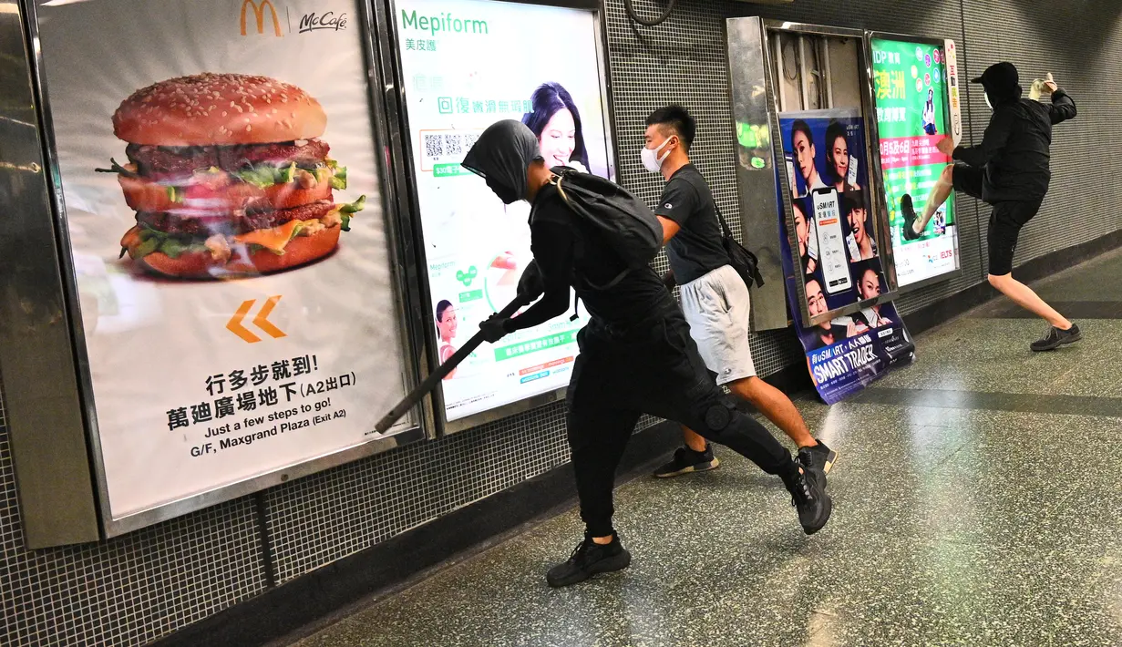 Sejumlah demonstran bertopeng merusak Stasiun Diamond Hill di Distrik Kowloon, Hong Kong, Senin (7/10/2019). Demonstran bertopeng merusak beberapa stasiun MTR di Hong Kong. (Philip FONG/AFP)