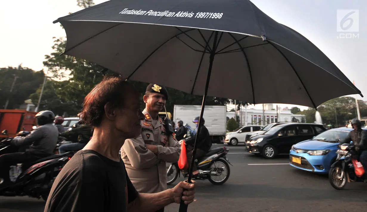 Polisi mengawal massa Jaringan Solidaritas Korban untuk Keadilan (JSKK) saat menggelar Aksi Kamisan di depan Istana Negara, Jakarta, Kamis (2/8). (Merdeka.com/Iqbal Nugroho)