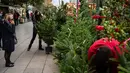 Orang-orang yang mengenakan masker melihat-lihat pohon Natal di Pekan Raya Santa Llucia, Barcelona, Spanyol, 1 Desember 2020. Pekan Raya Santa Llucia diadakan mulai 27 November - 23 Desember dengan kapasitas pengunjung dibatasi hanya 30 persen di tengah pandemi COVID-19. (Xinhua/Joan Gosa)
