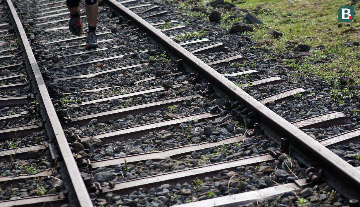 Jalur rel kereta api mulai menghilang mulai enam kilometer terakhir. Beberapa telah tertutup beton dan beralih fungsi menjadi jalanan. Peserta kemudian harus berlanjut melintasi jalur tanah. (Bola.com/Bagaskara Lazuardi)