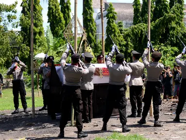 Petugas melepas tembakan salvo ke udara saat upacara pemakaman anggota Polsek Kuta, Aipda I Wayan Sudarsa di Jimbaran, Bali, Minggu (21/8). Prosesi secara institusi Polri itu dilakukan sebelum jenazah dibakar sesuai adat Hindu. (SONNY Tumbelaka/AFP)