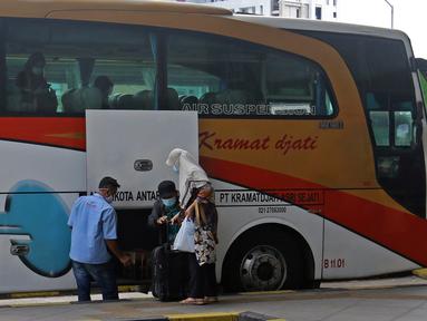 Petugas memasukkan barang bawaan penumpang ke dalam bagasi bus di Terminal Terpadu Pulo Gebang, Jakarta, Kamis (11/2/2021). Berdasarkan data Dishub hingga pukul 14.00 WIB, Terminal Terpadu Pulo Gebang telah memberangkatkan 466 pemudik menuju luar Jakarta. (Liputan6.com/Herman Zakharia)