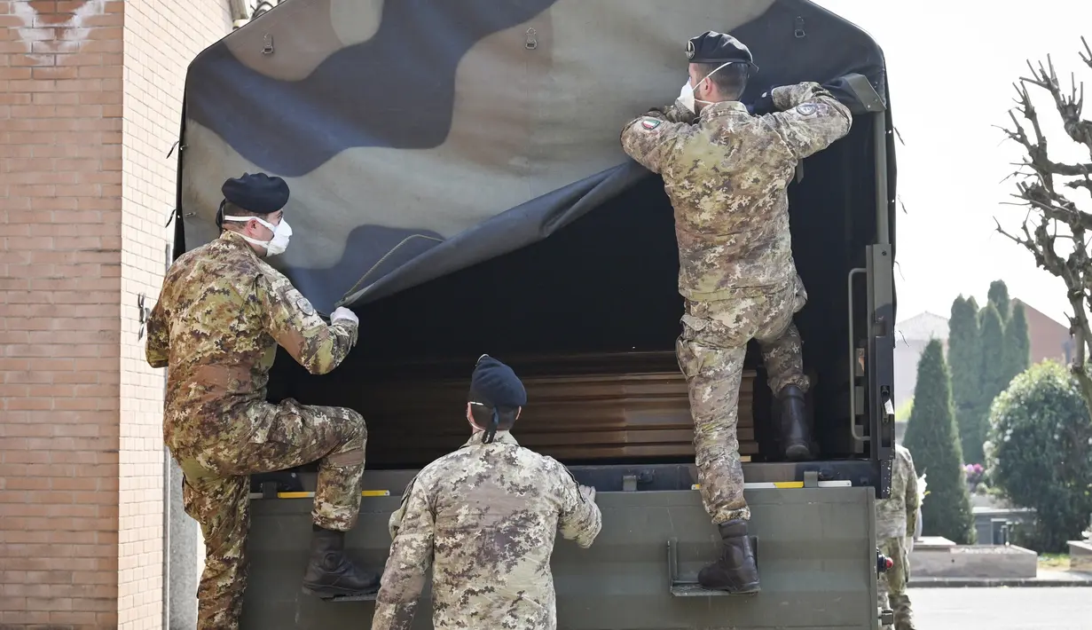 Tentara bersiap menurunkan peti mati berisi jasad korban virus corona COVID-19 dari Bergamo di Ferrara, Italia, Sabtu (21/3/2020). Hingga saat ini, sebanyak 4.825 orang dilaporkan meninggal akibat COVID-19 di Italia. (Massimo Paolone/LaPresse via AP)