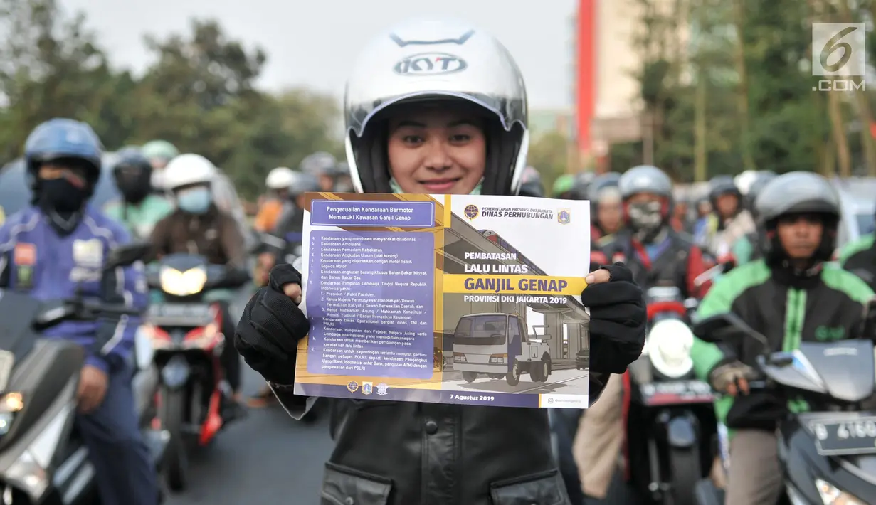 Petugas Dinas Perhubungan DKI Jakarta menunjukkan brosur saat melakukan sosialisasi uji coba perluasan sistem ganjil genap di kawasan Pramuka, Jakarta, Senin (12/8/2019). Durasi sistem ganjil genap diperpanjang mulai pukul 06.00-10.00 WIB dan 16.00-21.00 WIB. (merdeka.com