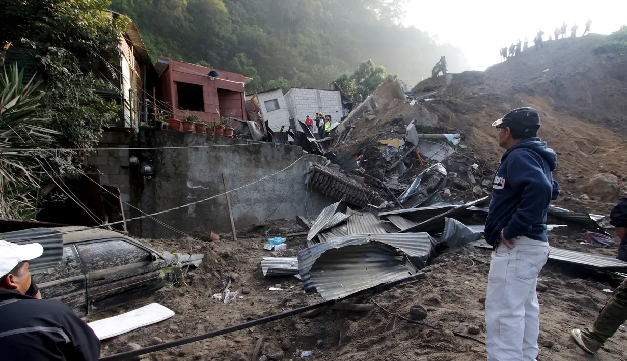 Warga melihat rumah rusak akibat tanah longsor di Santa Catarina Pinula, Guatemala (2/10/2015). Menurut media lokal, enam mayat ditemukan dari lumpur, dan sekitar 40 rumah hancur, setelah tanah longsor yang disebabkan hujan lebat. (REUTERS/Josue Decavele)