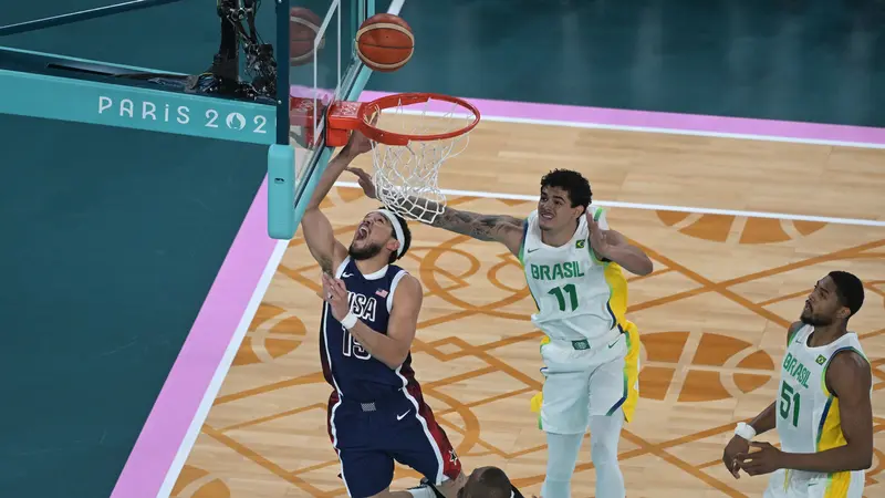 Pemain Amerika Serikat Devin Booker menerobos pertahanan Brasil di perempat final Olimpiade 2024