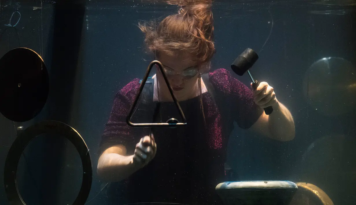 Salah satu anggota Between Music memainkan alat musik mereka saat latihan jelang Konser Underwater AquaSonic di Aarhus, Denmark, Rabu (19/4). (AFP PHOTO / Jonathan NACKSTRAND)