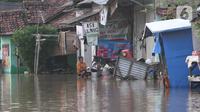 Aktivitas warga saat banjir di Desa Sukajaya, Serang, Banten, Rabu (2/3/2022). Banjir yang melanda kawasan Masjid Banten Lama setelah curah hujan tinggi mengguyur Kota Serang beberapa hari lalu mengakibatkan Kali Cibanten meluap dan menggenangi 22 titik. (merdeka.com/Imam Buhori)