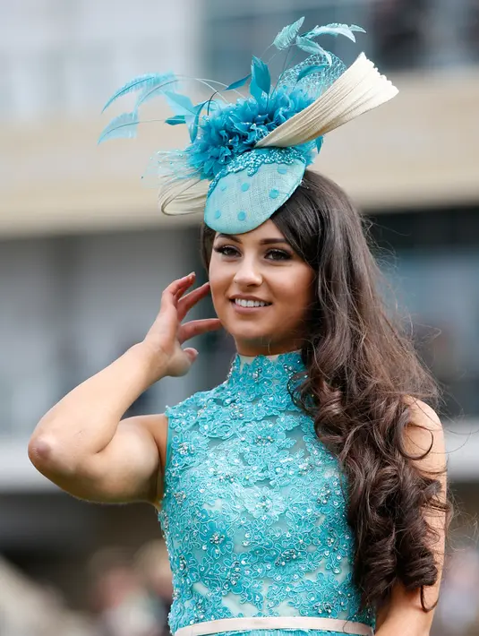 Senyum wanita cantik mengunakan topi unik jelang pembukaan ajang Pacuan Kuda dalam Festival Cheltenham di Inggris (16/3). Para wanita yang menghadiri pacuan kuda ini terkenal dengan gaya modisnya dan topi fancy yang dikenakannya. (REUTERS/Paul Childs)