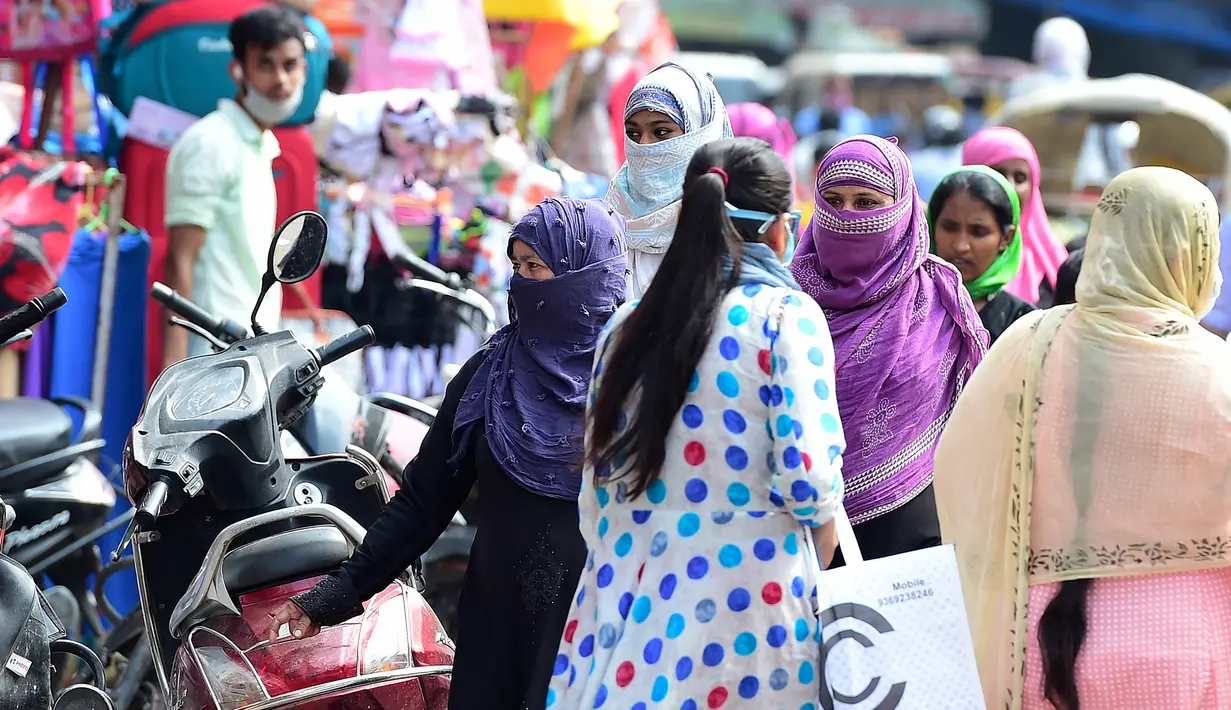 Orang-orang berjalan dan berbelanja di pasar di Chowk, Allahabad, Senin (17/8/2020). Kasus kematian akibat Covid-19 di India telah melewati 50 ribu pada Senin (17/8), dengan kawasan pedesaan dan kota kecil yang lemah dalam sistem kesehatan menjadi daerah terdampak paling parah. (SANJAY KANOJIA/AFP)