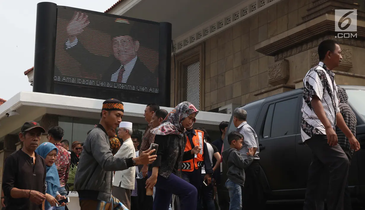 Warga melihat prosesi pemakaman Presiden ke-3 RI BJ Habibie di TMP Kalibata, Jakarta, Kamis (12/9/2019). Habibie meninggal setelah mendapat perawatan intensif selama beberapa hari terakhir di RSPAD Gatot Subroto Jakarta Pusat. (Liputan6.com/Helmi Fithriansyah)