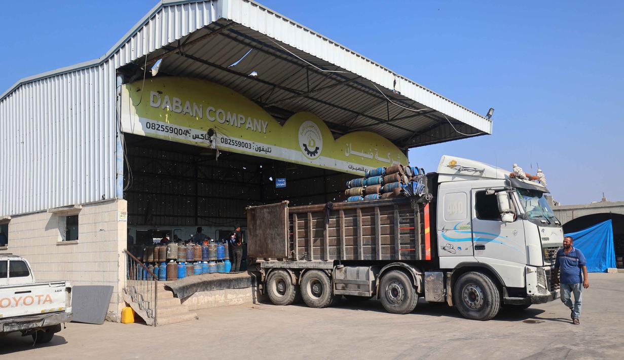 Distribusi gas di Gaza merupakan bagian dari upaya bantuan kemanusiaan yang sangat dibutuhkan di tengah krisis yang sedang berlangsung di wilayah tersebut, yang menyebabkan kekurangan bahan bakar dan kebutuhan pokok lainnya. Tampak dalam foto, sebuah truk diisi dengan tabung gas setelah diisi ulang untuk pertama kalinya dalam setahun, di stasiun pengisian resmi di kamp pengungsi Nuseirat, di bagian tengah Jalur Gaza, pada 10 November 2025. (Eyad Baba/AFP)