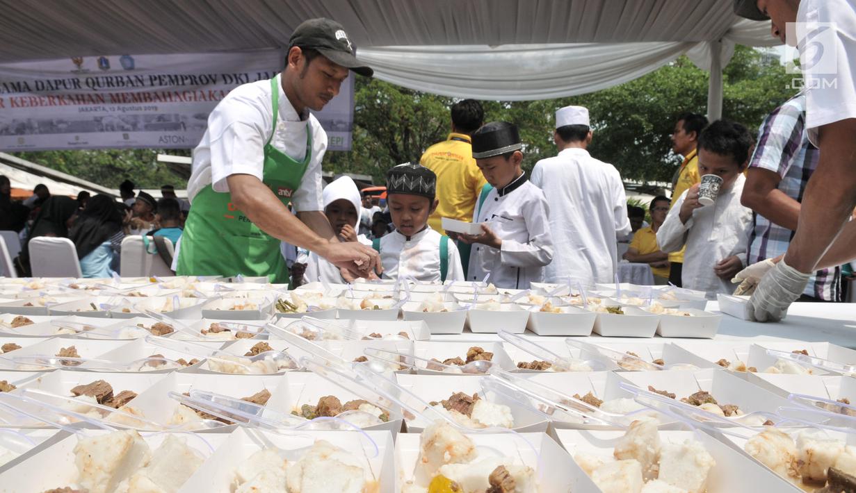 Juru masak membagikan daging kurban ala hotel bintang lima kepada anak-anak yatim saat peluncuran Dapur Kurban di Monas, Jakarta, Senin (12/8/2019). Pemprov DKI Jakarta menggandeng juru masak profesional dalam mengolah daging kurban. (merdeka.com/Iqbal Nugroho)