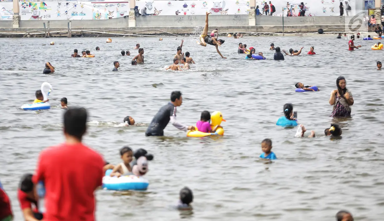 Pengunjung berenang di Pantai Lagoon, Ancol, Jakarta Utara, Jumat (17/8). Warga Jakarta dan sekitarnya memanfaatkan libur HUT ke-73 Republik Indonesia dengan berwisata ke kawasan Ancol. (Liputan6.com/Faizal Fanani)