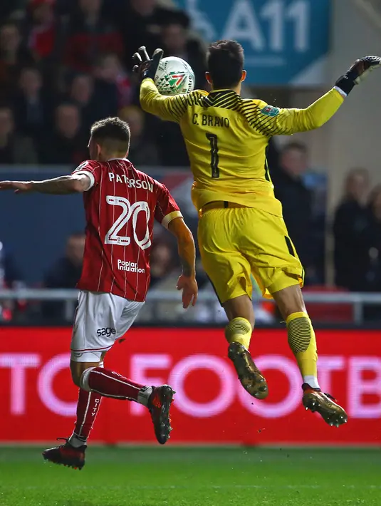 Kiper Manchester City, Claudio Bravo berusaha menyelamatkan bola yang ditendang pemain Bristol City Jamie Paterson pada leg kedua semifinal Piala Liga di Ashton Gate, Rabu (24/1). Manchester City menang tipis denga skor 3-2. (Geoff CADDICK/AFP)