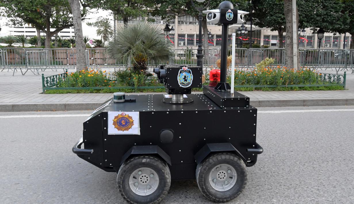 Robot polisi Tunisia berpatroli selama kebijakan penguncian (lockdown) di sepanjang Avenue Habib Bourguiba, pusat ibu kota Tunis, Rabu (1/4/2020). Robot itu dikendalikan dari jarak jauh untuk berkeliling dan membagikan sanksi terhadap warga yang melanggar aturan karantina. (FETHI BELAID/AFP)