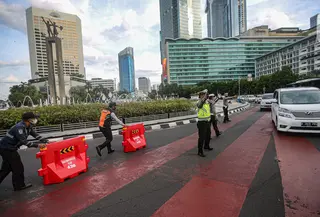 Petugas gabungan mengatur lalu lintas saat uji coba rekayasa lalu lintas di kawasan Bundaran HI, Jakarta Pusat, Senin sore (4/7/2022). Rekayasa lalu lintas di Bundaran HI merupakan salah satu upaya memperlancar arus lalin di Jenderal Sudirman Thamrin. (Liputan6.com/Faizal Fanani)