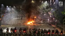 Polisi menembakan petasan dan gas air mata ke kerumunan massa di kawasan Pejompongan, Jakarta, Senin (30/9/2019). Demonstrasi menolak UU KPK hasil revisi dan RUU KUHP di depan Gedung DPR/MPR berakhir ricuh. (Liputan6.com/JohanTallo)
