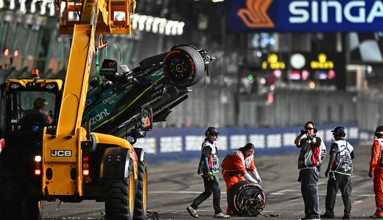 Mobil pembalap Aston Martin, Lance Stroll dievakuasi setelah menabrak dinding lintasan saat sesi Kualifikasi 1 (Q1) Formula 1 GP Singapura 2023 yang berlangsung di Sirkuit Marina Bay, Singapura, Sabtu (16/03/2023). (AFP/Lillian Suwanrumpha)