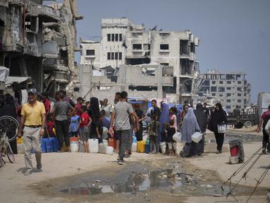 Di tengah panas terik musim panas, warga Palestina mengantre untuk mengambil air dari titik distribusi di Kota Gaza, Selasa 12 Agustus 2025. (AP Photo/Jehad Alshrafi)