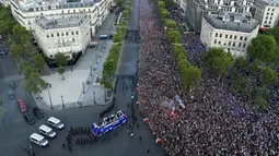 Jutaan fans menyambut kedatangan timnas Prancis di Champs-Elysee avenue, Paris, (16/7/2018). Sambutan meriah tersebut adalah bagian dari perayaan keberhasilan Prancis meraih trofi Piala Dunia 2018. (AFP/Bertrand Guay)
