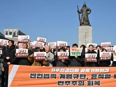 Para pengunjuk rasa memegang plakat dalam unjuk rasa yang menyerukan pengunduran diri Presiden Korea Selatan Yoon Suk Yeol di Lapangan Gwanghwamun di Seoul pada 4 Desember 2024. (ANTHONY WALLACE/AFP)