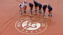 Petugas membersihkan lapangan dari lumpur pada turnamen Prancis Terbuka 2016 di Roland Garros (28/5/2016).(AFP/Philippe Lopez)