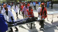 Petugas membawa korban dari serangan bom mobil di Mogadishu, Somalia, Rabu (25/1). Kelompok Alshabaab mengklaim berada di balik serangan tersebut. (AP Photo)