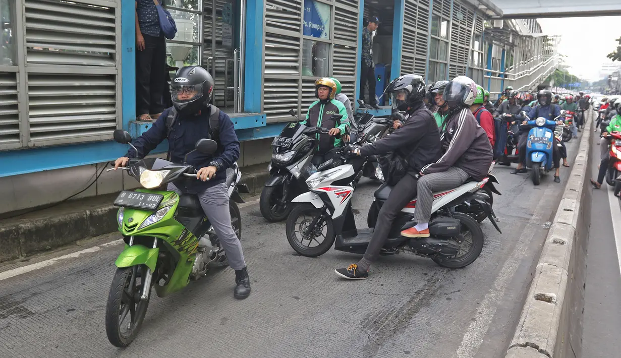 Sejumlah pengendara sepeda motor mencoba menghindar saat polisi menggelar razia bagi penerobos jalur Transjakarta di Jalan Sultan Agung, Manggarai, Jakarta, Rabu (12/2/2020). Pengendara kerap melintasi jalur Transjakarta untuk menghindari kemacetan lalu lintas. (Liputan6.com/Herman Zakharia)