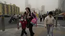 Warga berjalan di jalan saat badai debu melanda Beijing, Jumat, 10 Maret 2023. Konsentrasi partikel PM2.5 kecil yang dapat mencapai jauh ke dalam paru-paru dan aliran darah memasuki kisaran berbahaya di situs pemantauan kualitas udara, dengan situs web IQAir menunjukkan indeks kualitas udara 1.093, tingPetugas polisi China memantau persimpangan saat badai debu melanda Beijing. (AP Photo/Ng Han Guan)